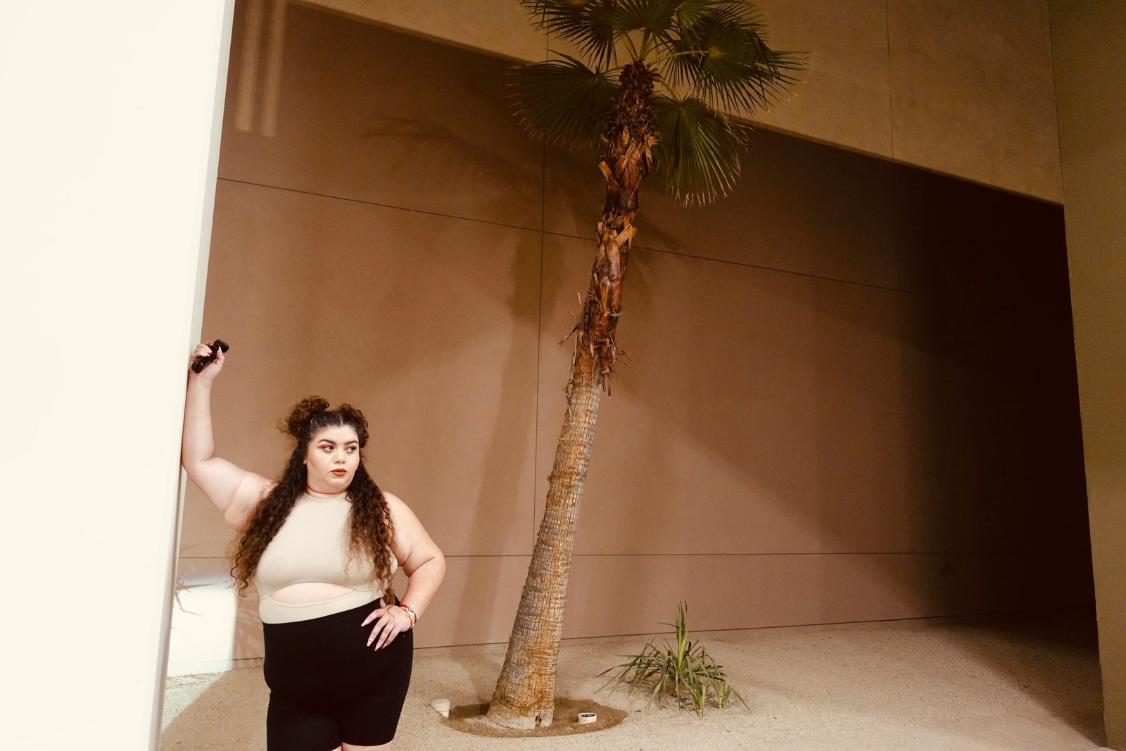 a woman standing in front of a palm tree